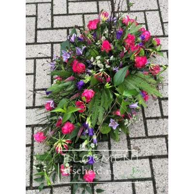 Rouwarrangement in druppelvorm van bonte gekleurde bloemen
